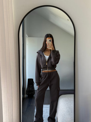 Model wearing INTIMISSY Studio Plush Cargo Pants in Truffle Charcoal styled for everyday streetwear