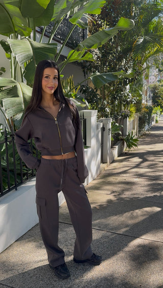Model wearing INTIMISSY Studio Plush Cargo Pants in Truffle Charcoal styled for everyday streetwear