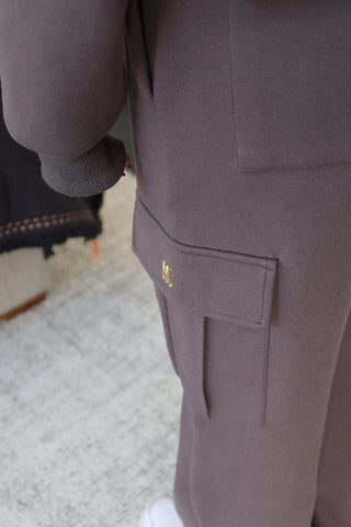 Detail of the 360GSM plush fabric on the INTIMISSY Truffle Charcoal pants showing soft premium texture and gold signature hardware